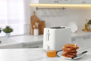 Photo of Breakfast served in kitchen. Toaster, crunchy bread and honey on white marble table. Space for text