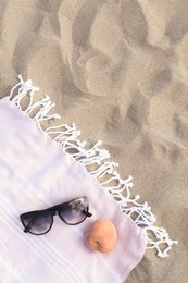 Photo of Beautiful sunglasses and peach on blanket, top view. Space for text