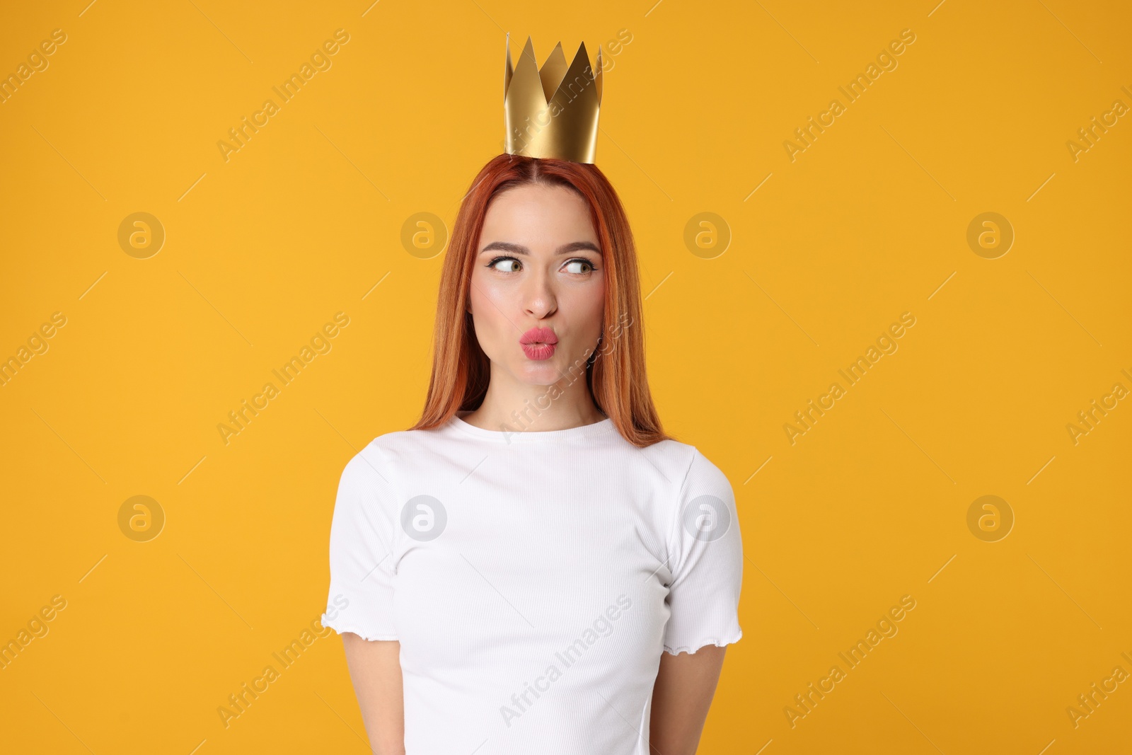 Photo of Beautiful young woman with princess crown on orange background