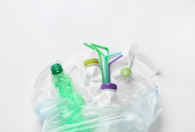 Photo of Pile of different plastic items on white background, flat lay