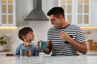 Photo of Dad and his son having fun in kitchen. Happy Father's Day