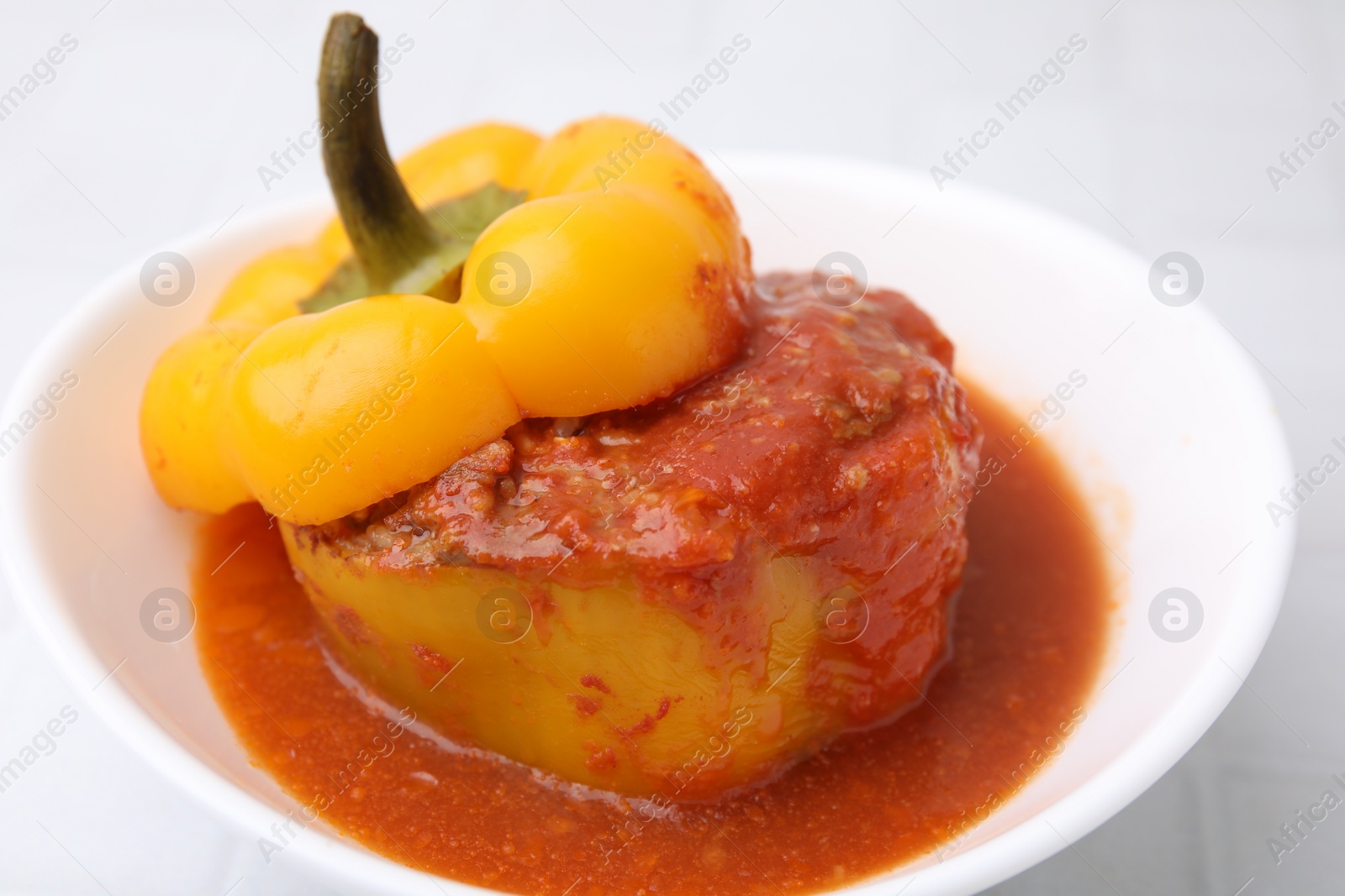 Photo of Delicious stuffed bell peppers on white tiled table, closeup