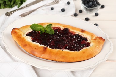 Delicious sweet cottage cheese pastry with cherry jam served on white wooden table