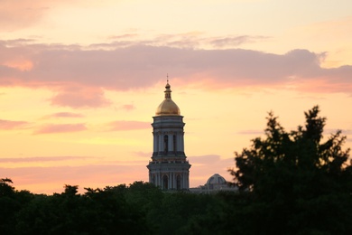 Photo of KYIV, UKRAINE - MAY 23, 2019: Christian church with dome and trees in evening
