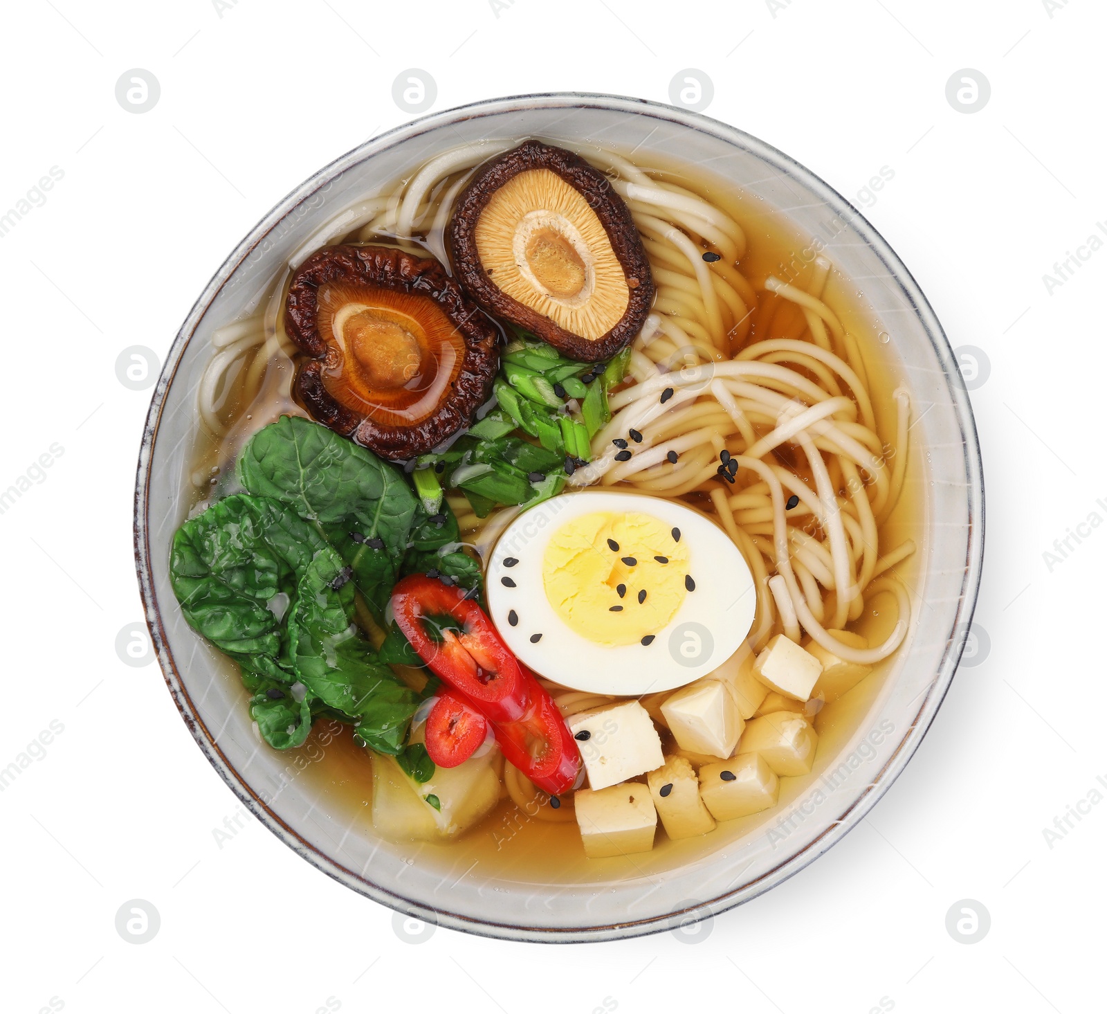 Photo of Delicious vegetarian ramen with egg, mushrooms, tofu and vegetables in bowl isolated on white, top view. Noodle soup