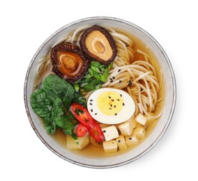 Photo of Delicious vegetarian ramen with egg, mushrooms, tofu and vegetables in bowl isolated on white, top view. Noodle soup