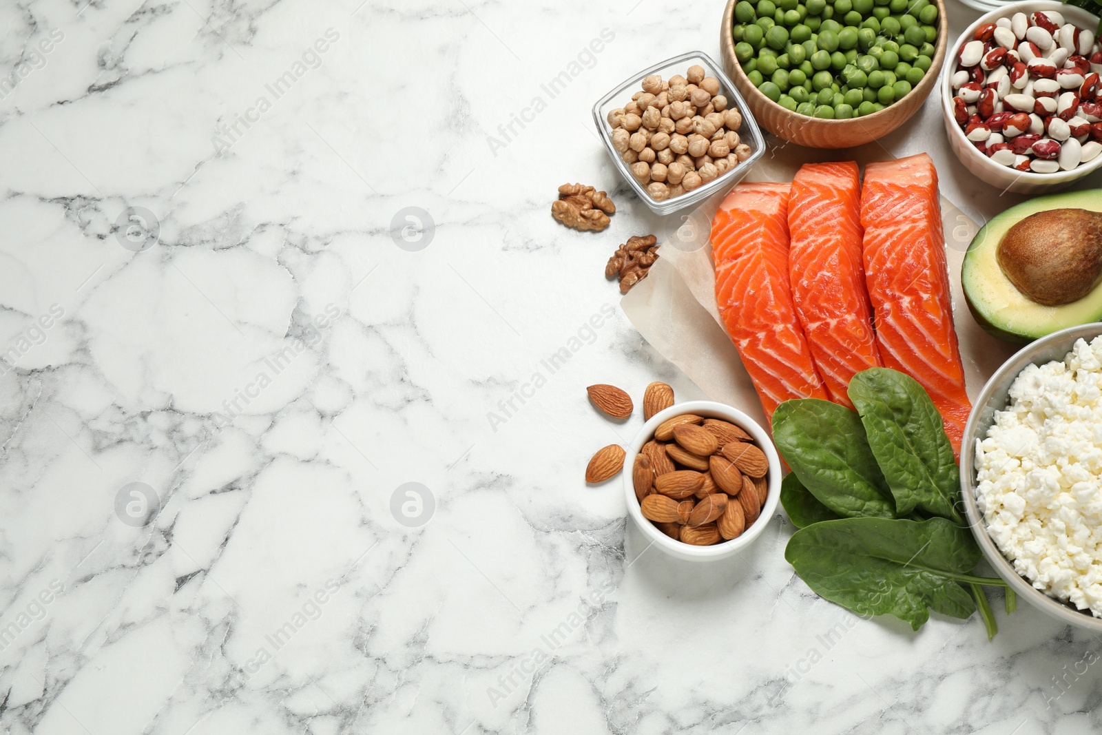 Photo of Products rich in protein on white marble table, flat lay. Space for text