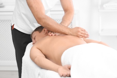 Relaxed man receiving back massage in wellness center