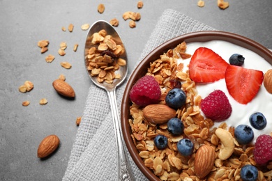 Photo of Tasty homemade granola served on grey table, flat lay. Healthy breakfast