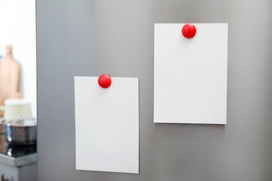 Sheets of paper and photos with magnets on refrigerator door indoors. Space for text