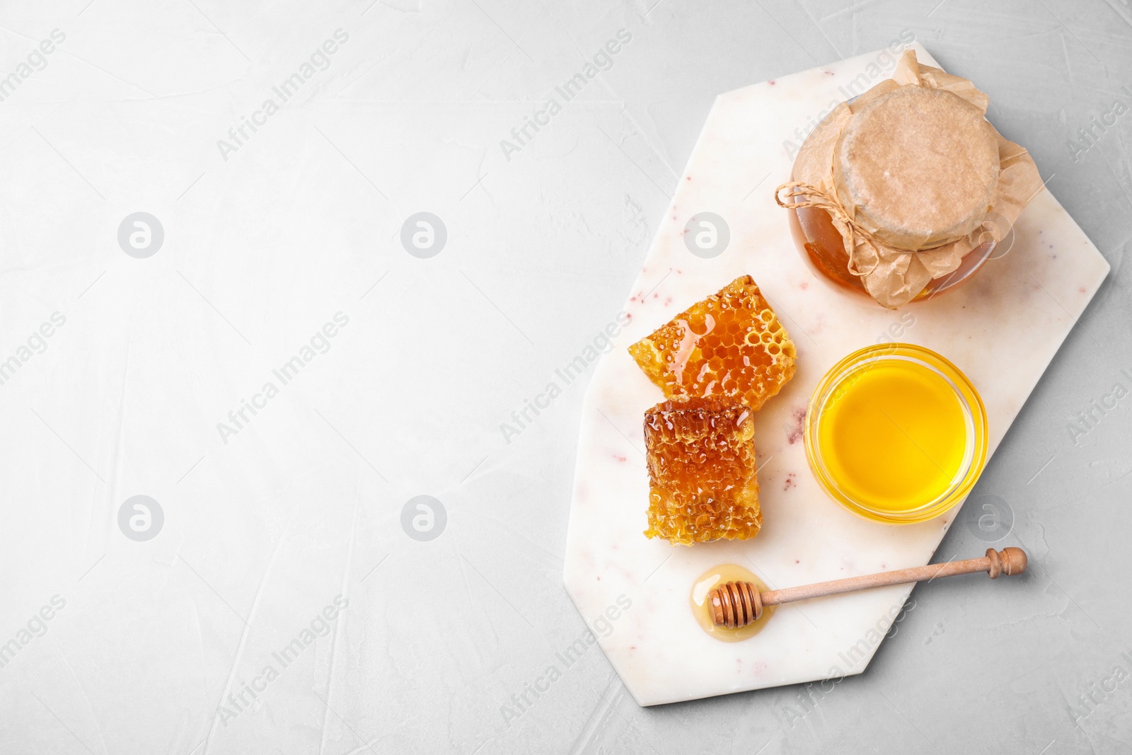 Photo of Tasty honey on light grey table, top view. Space for text