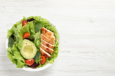 Delicious salad with chicken, cherry tomato and avocado on white wooden table, top view. Space for text