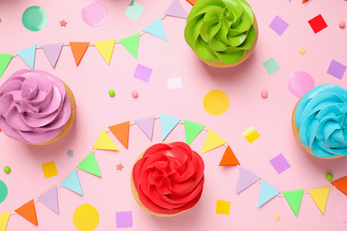 Colorful birthday cupcakes on light pink background, flat lay