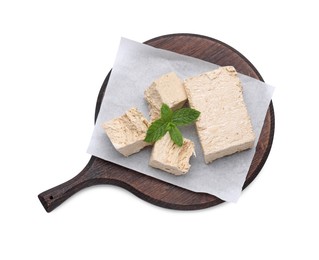 Photo of Board with pieces of tasty halva and mint isolated on white, top view