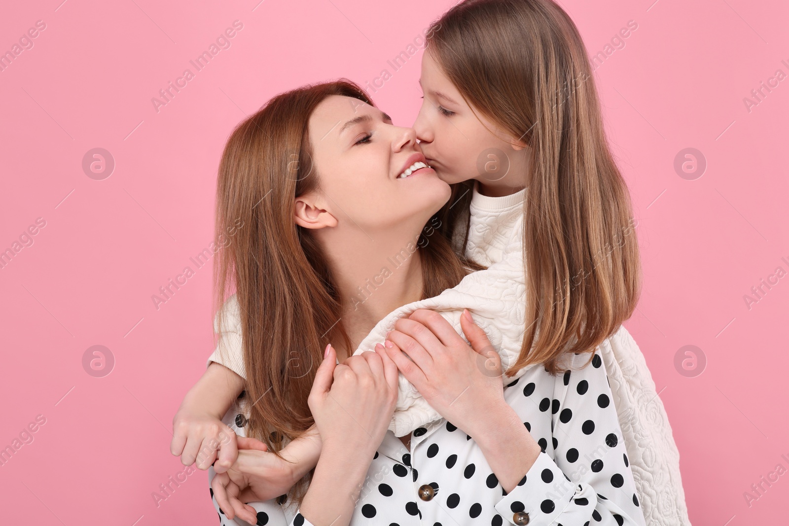 Photo of Portrait of happy mother and her cute daughter on pink background