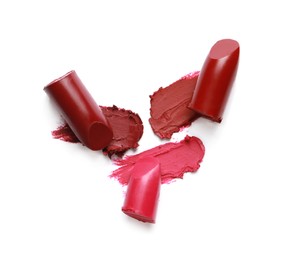 Photo of Different lipsticks and smears on white background, top view