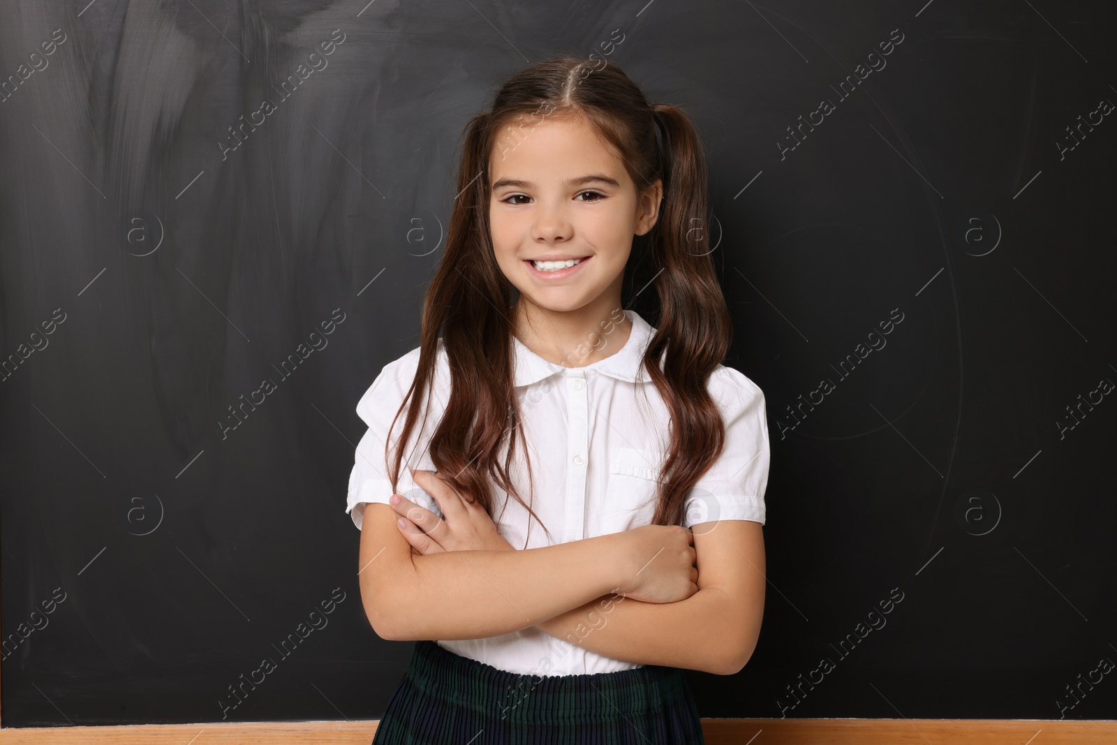 Photo of Back to school. Cute girl near chalkboard