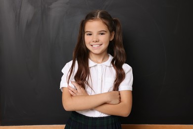 Photo of Back to school. Cute girl near chalkboard