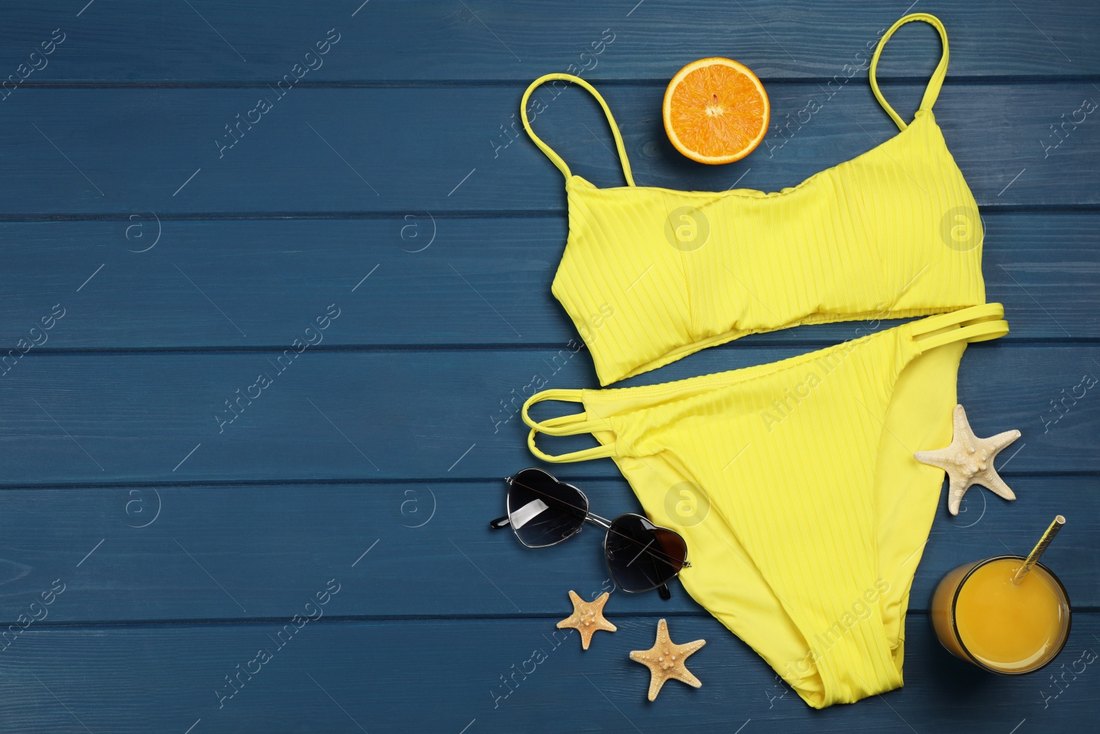 Photo of Flat lay composition with beach objects on blue wooden background, space for text