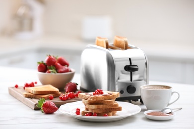 Photo of Modern toaster and tasty breakfast on white marble table in kitchen