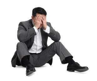 Photo of Tired businessman in suit sitting on white background