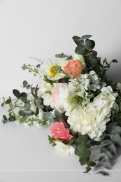 Photo of Bouquet of beautiful flowers on white wooden table, closeup