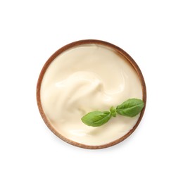 Photo of Mayonnaise with basil leaves in wooden bowl isolated on white, top view