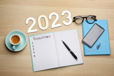 Photo of Making resolutions for 2023 new year. Flat lay composition with notebook on wooden table