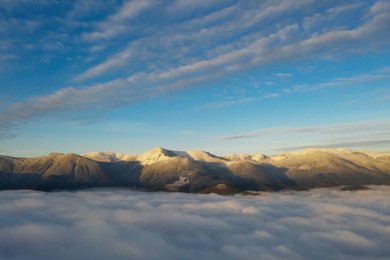 Image of Aerial view of beautiful mountains above clouds