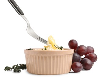 Photo of Taking tasty baked camembert with fork from bowl on white background