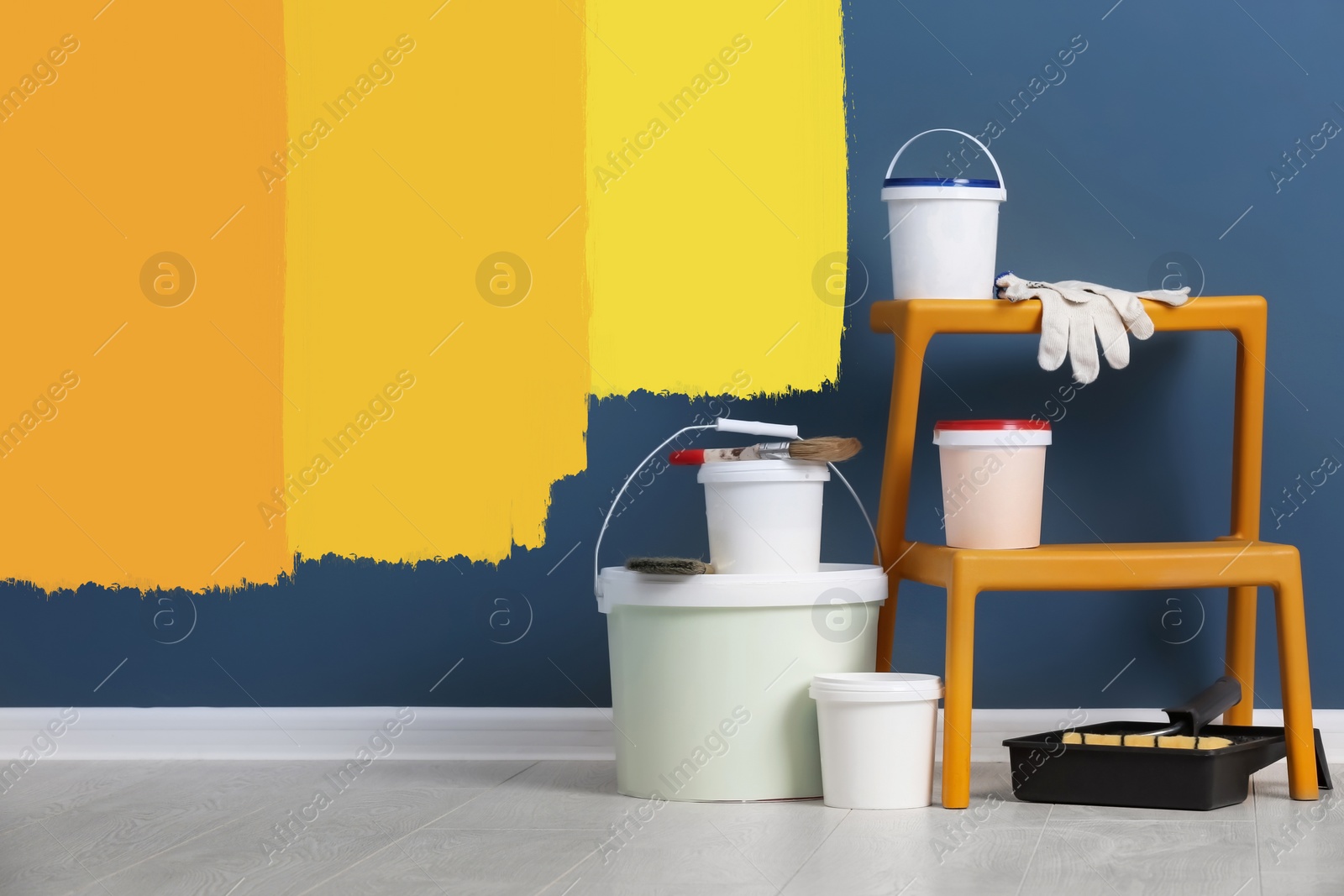 Image of Set with decorator tools and paint on floor near color wall