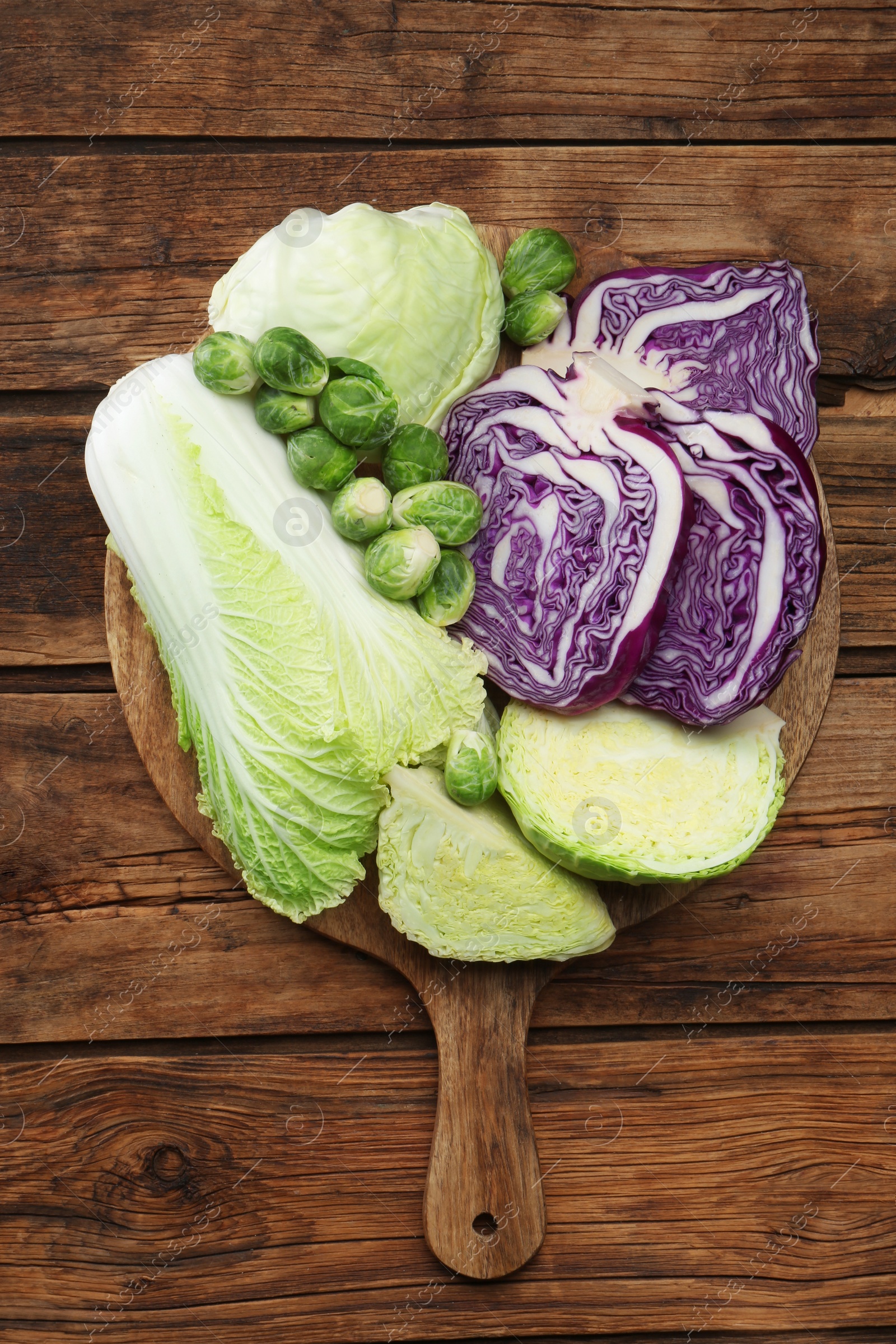 Photo of Different types of cabbage on wooden table, top view