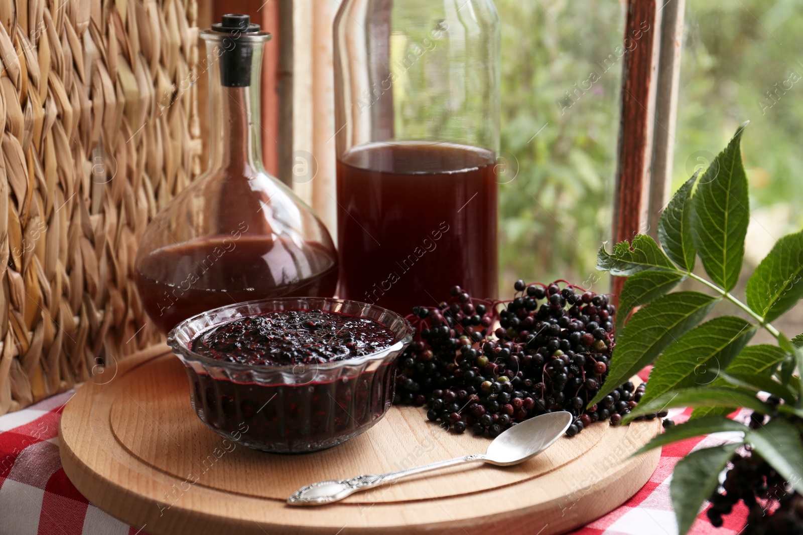 Photo of Elderberry drink and jam with Sambucus berries on table near window