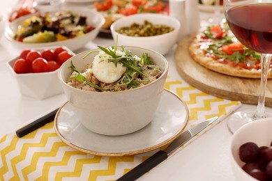 Photo of Bowl of oatmeal with poached egg, arugula and cheese served on buffet table for brunch