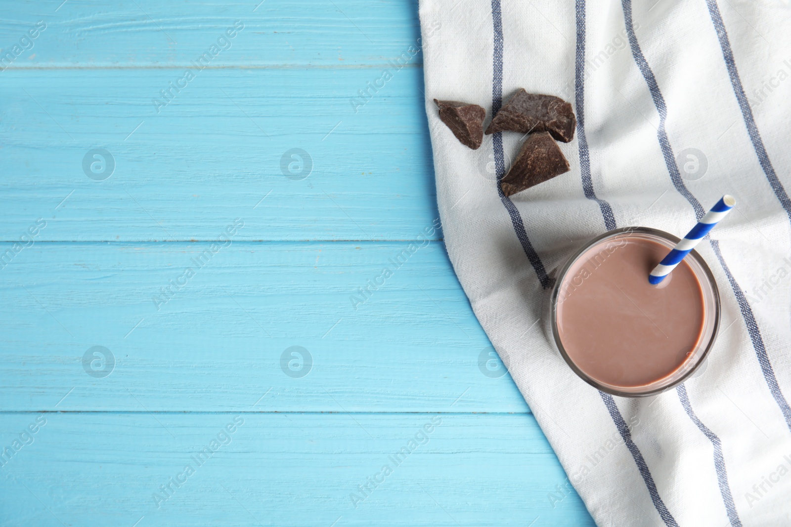 Photo of Flat lay composition with glass of tasty chocolate milk and space for text on wooden background. Dairy drink