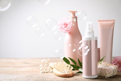 Photo of Set of hair cosmetic products, flowers and soap bubbles on white background. Space for text