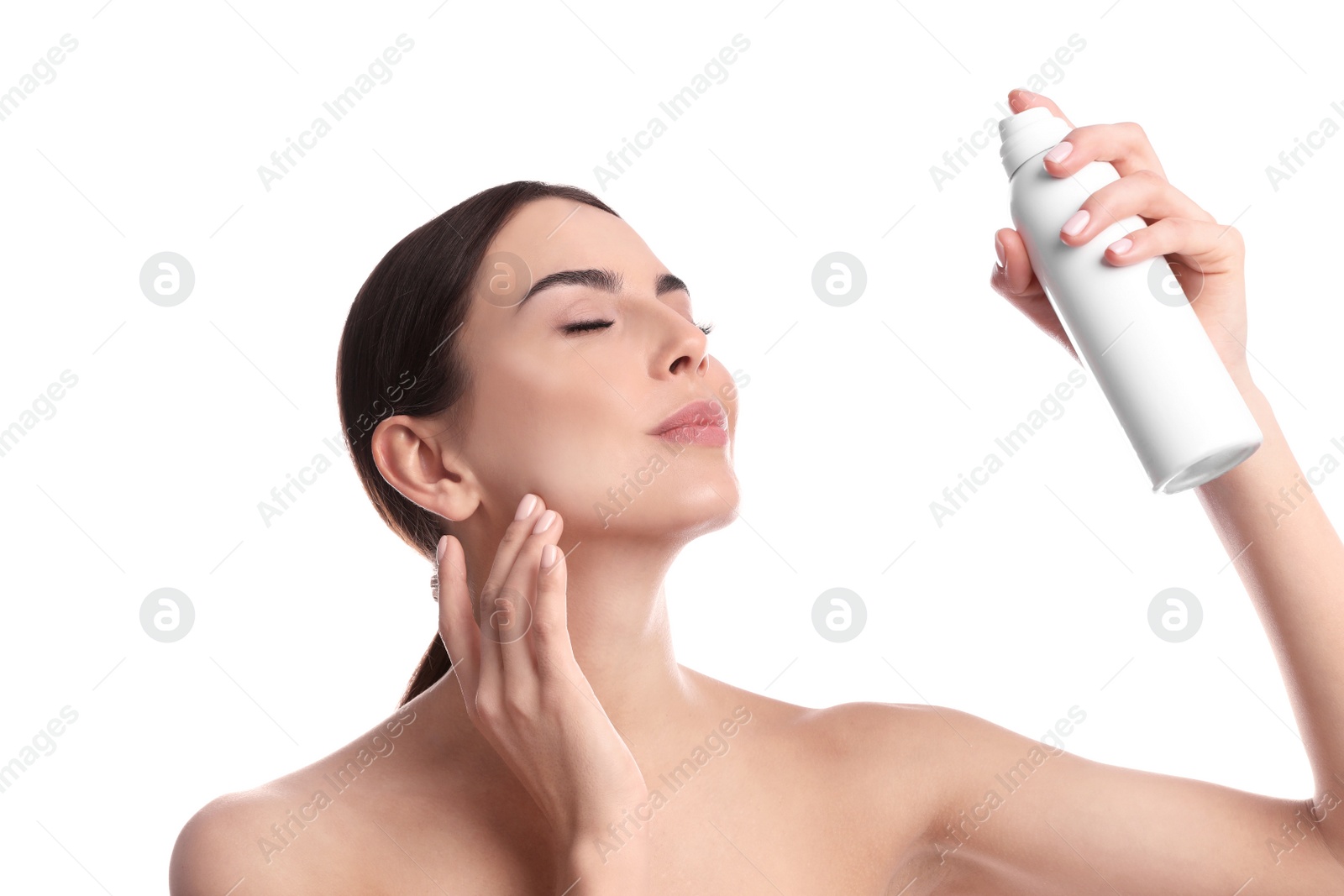 Photo of Young woman applying thermal water on face against white background. Cosmetic product