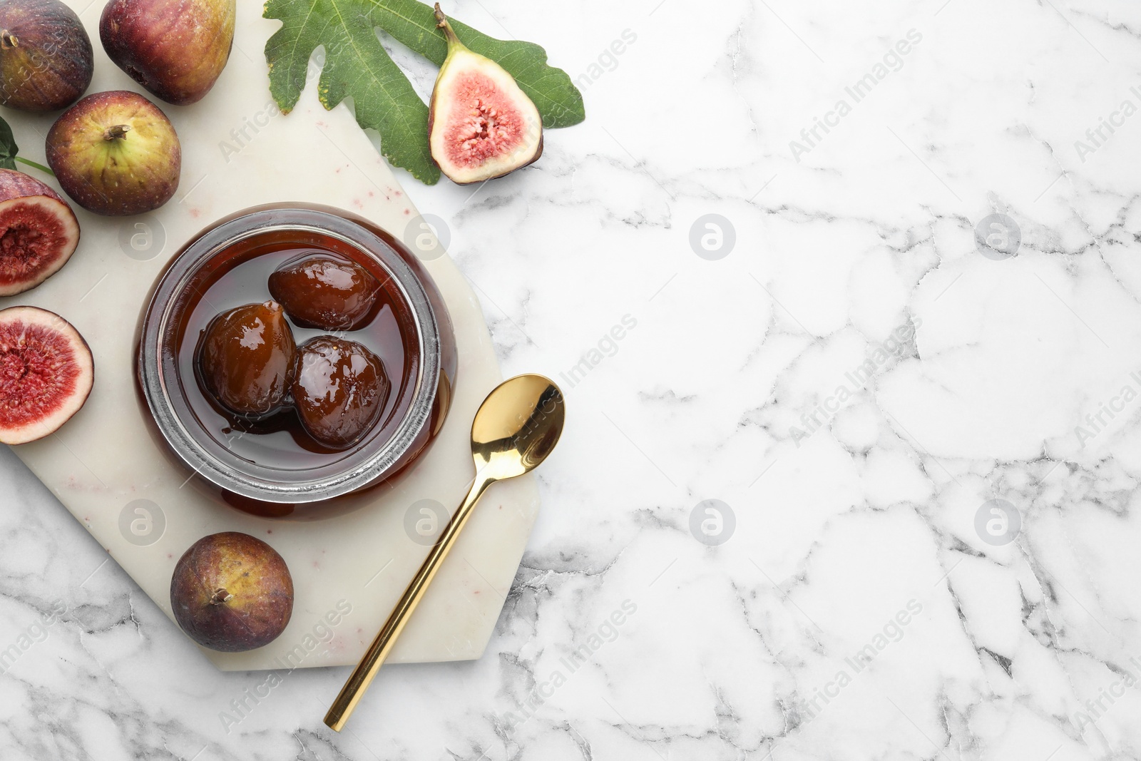 Photo of Jar of tasty sweet jam and fresh figs on white marble table, flat lay. Space for text