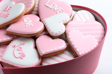 Delicious heart shaped cookies in box on white table, closeup. Valentine's Day