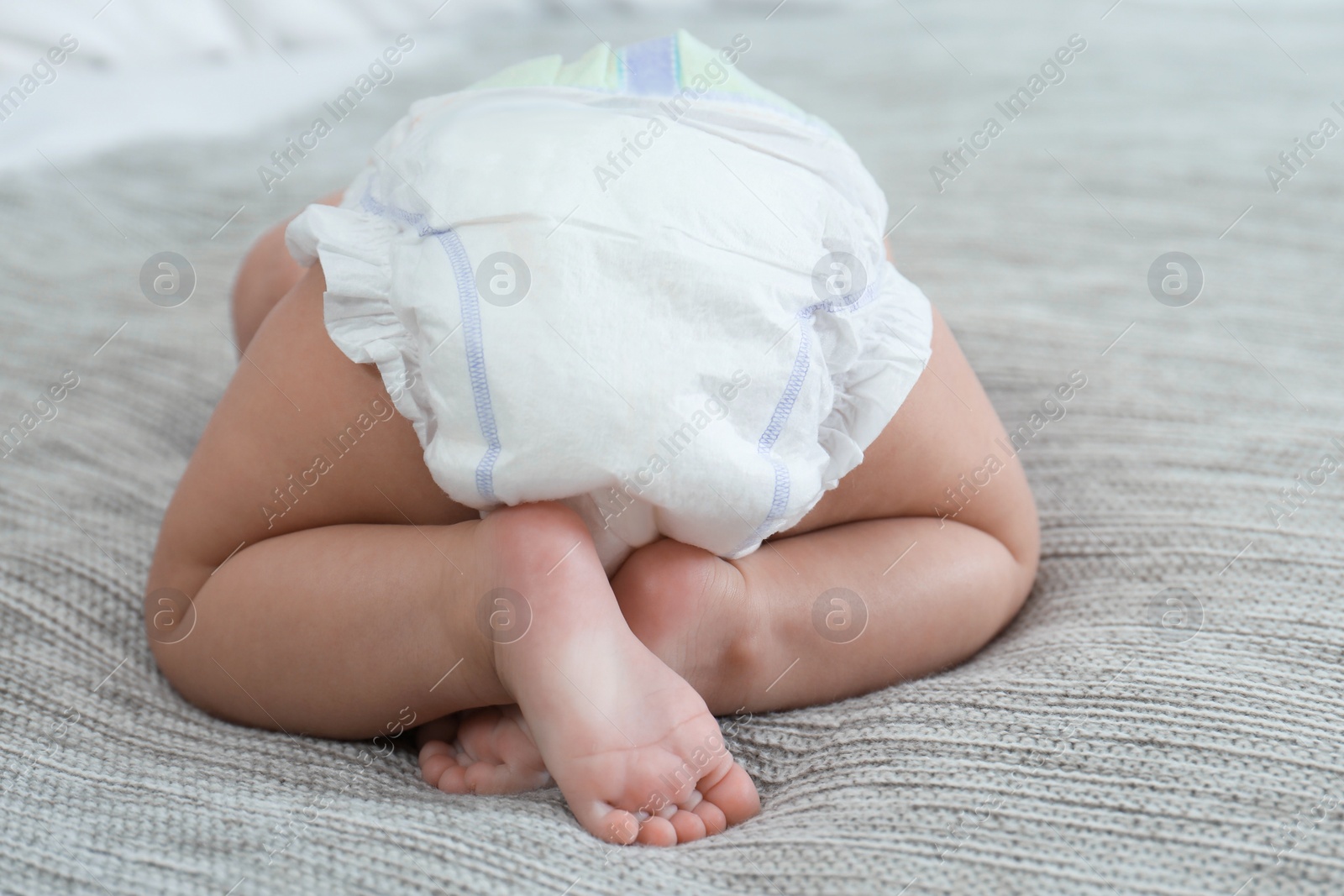 Photo of Cute little baby in diaper on bed