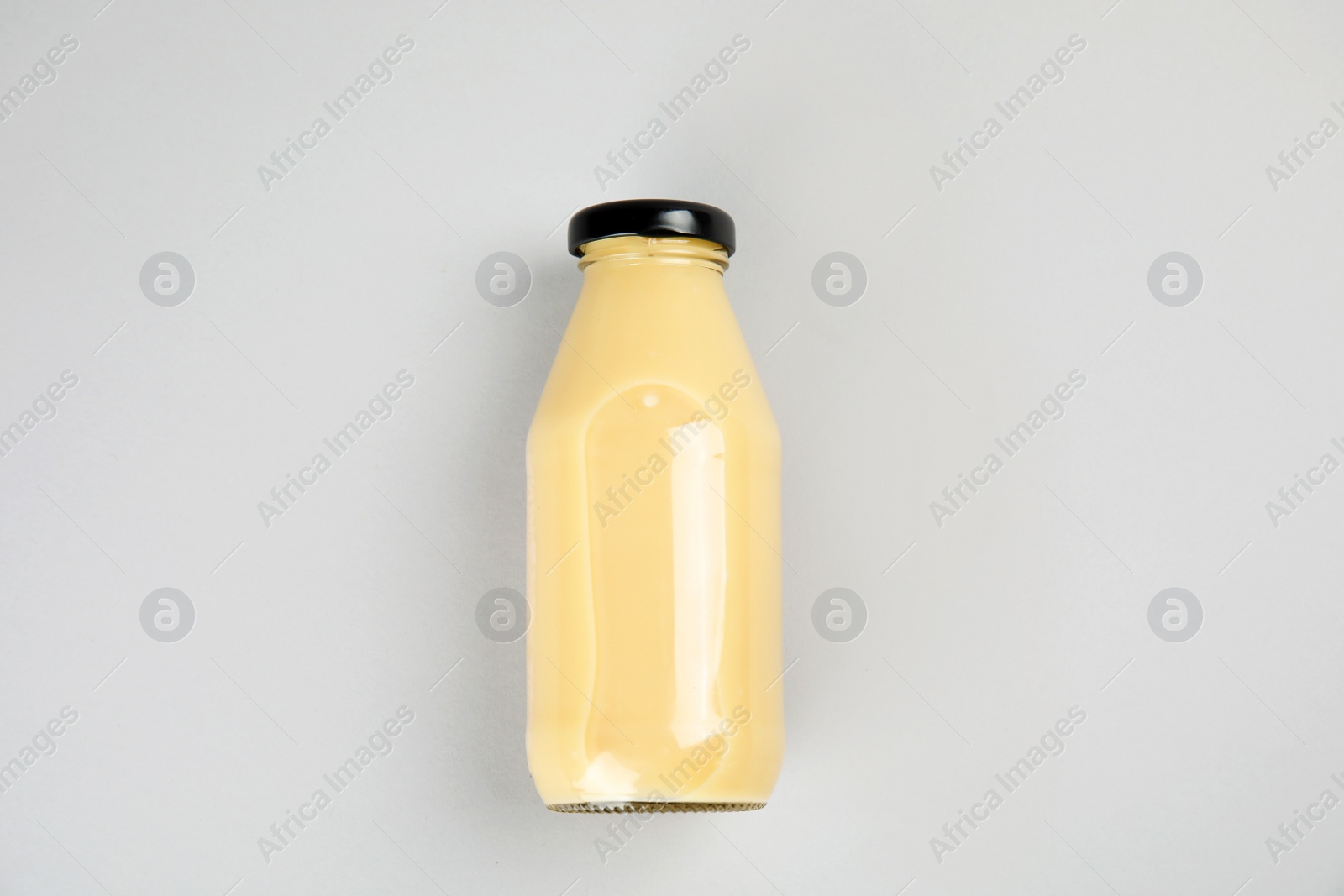 Photo of One bottle with tasty drink on color background, top view