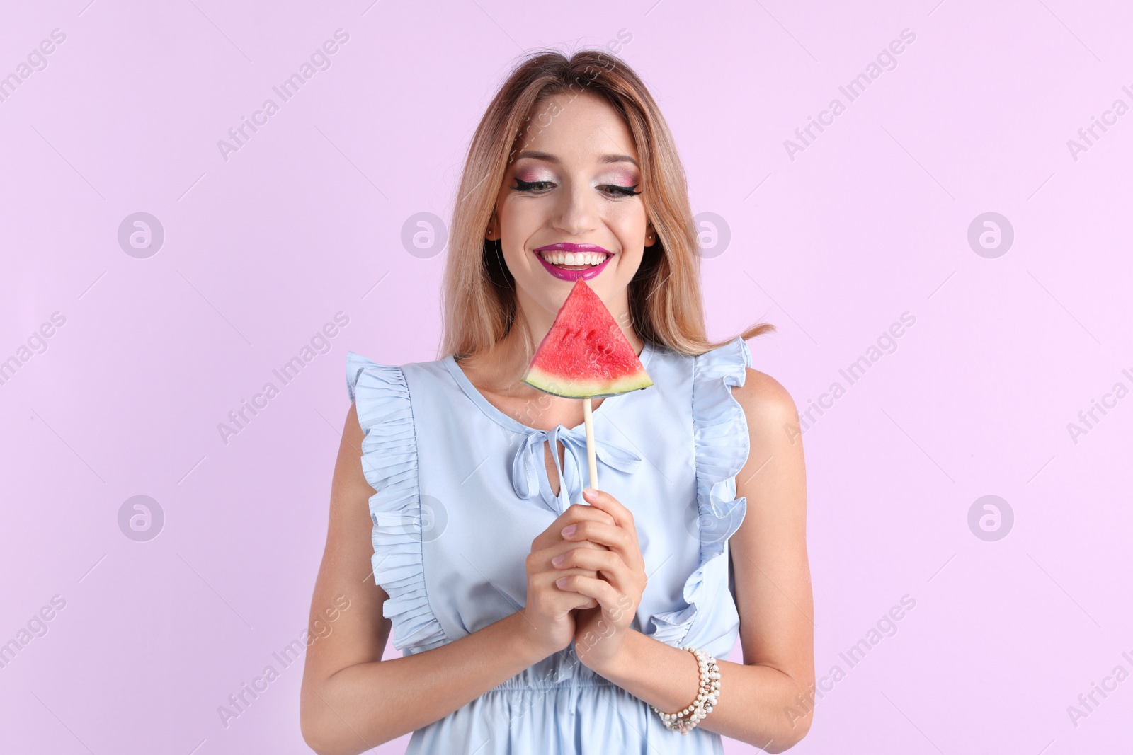 Photo of Pretty young woman with juicy watermelon on color background