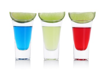 Photo of Different shooters in shot glasses and lime wedges isolated on white. Alcohol drink