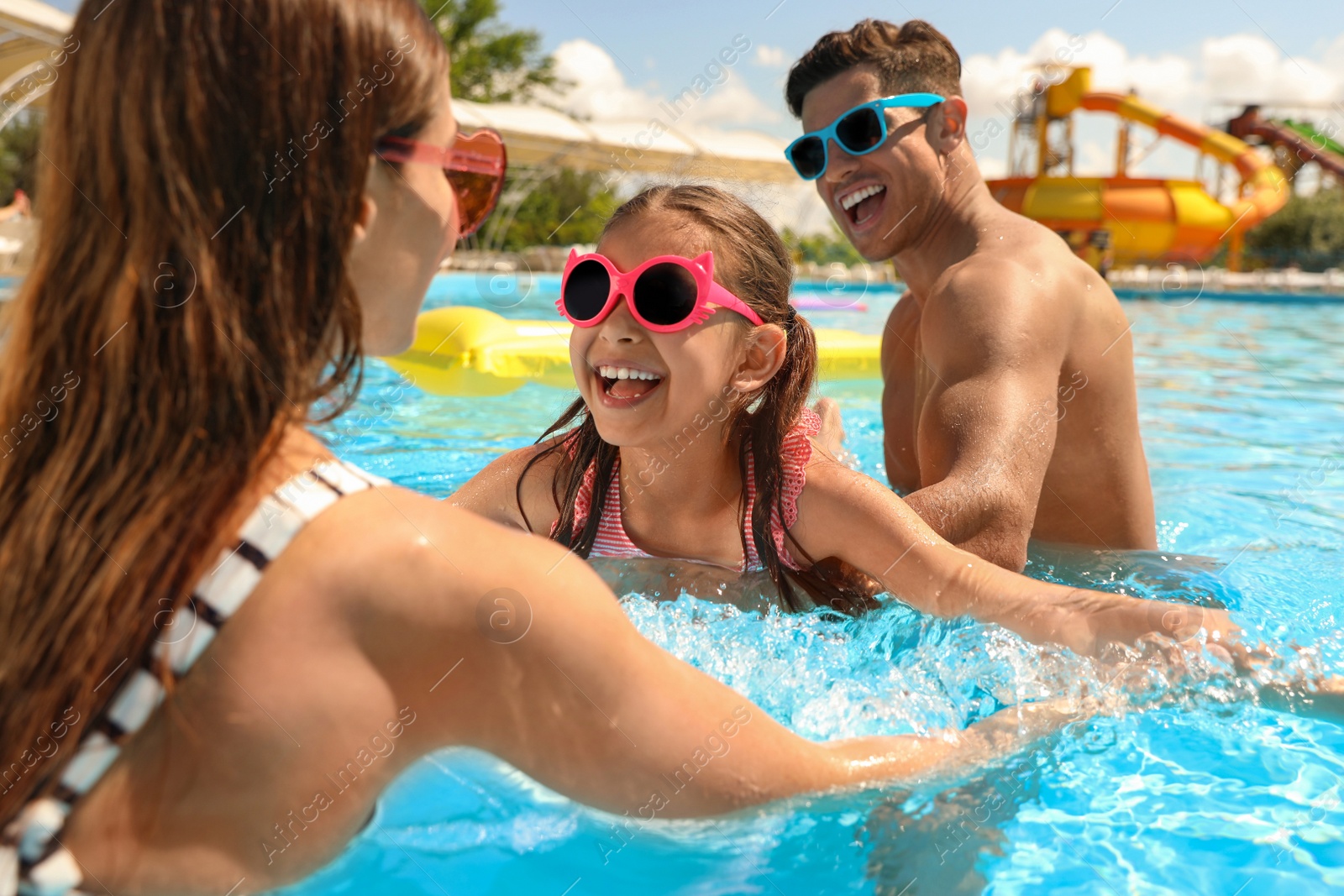 Photo of Happy family in swimming pool. Summer vacation