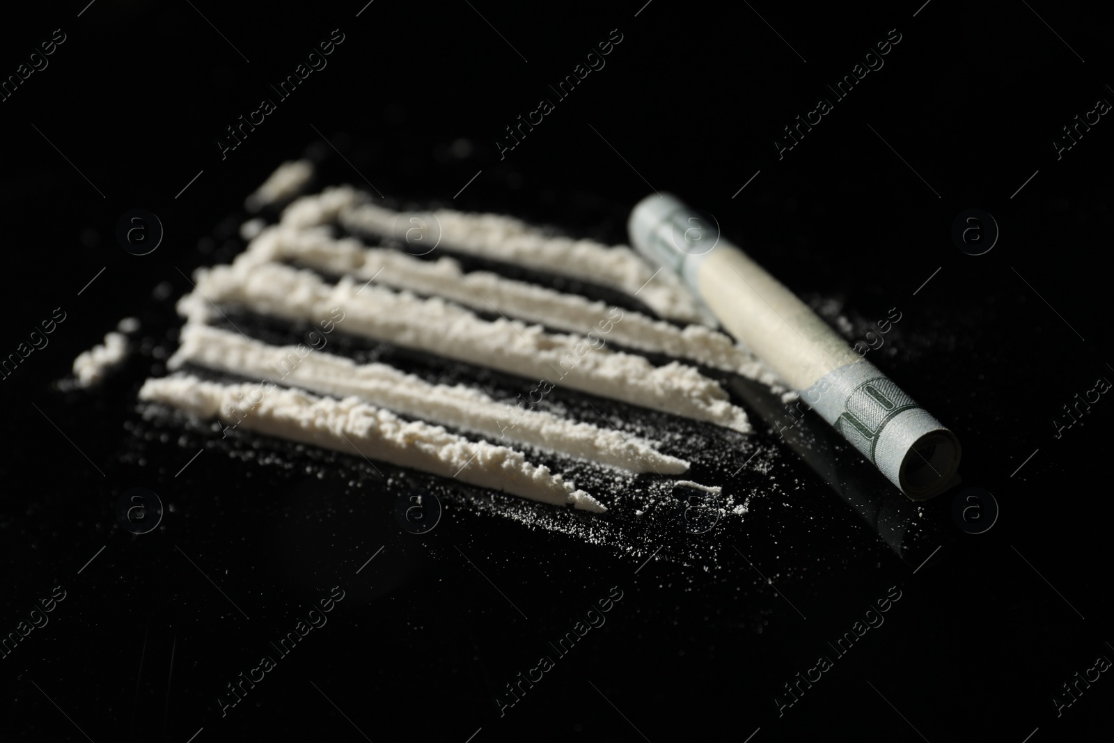 Photo of Drug addiction. Cocaine and rolled dollar banknote on black table, closeup