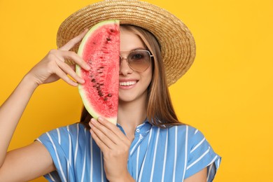 Beautiful girl with slice of watermelon on yellow background