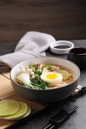 Photo of Bowl of vegetarian ramen served on grey table