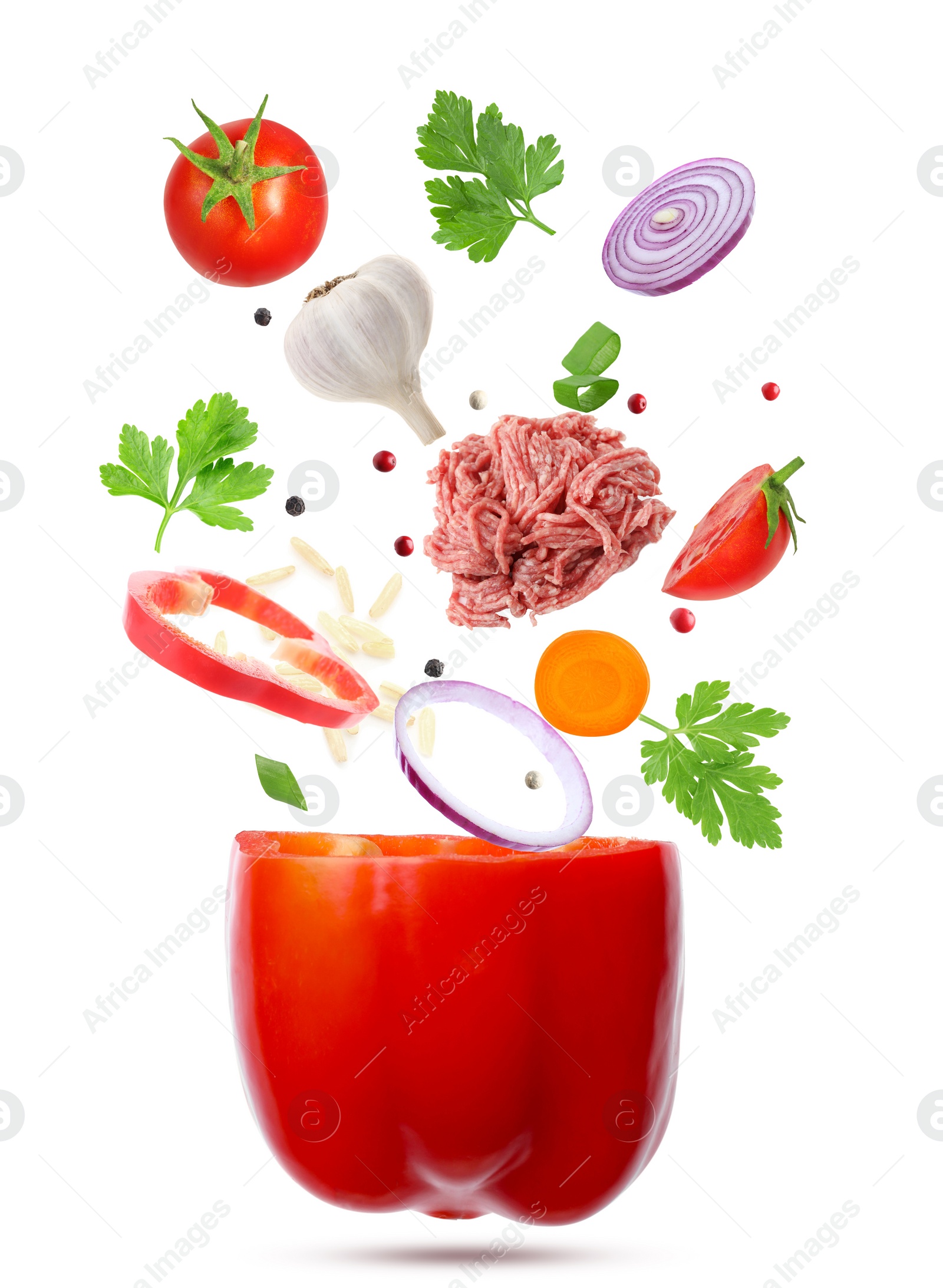 Image of Stuffed pepper recipe. Fresh ingredients falling into bell pepper on white background