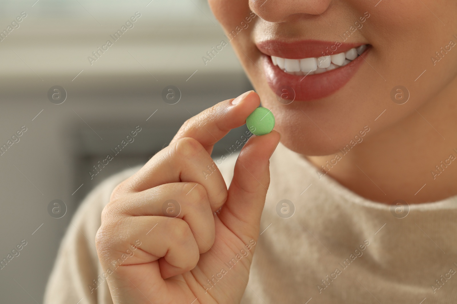 Photo of Young woman taking dietary supplement pill, closeup