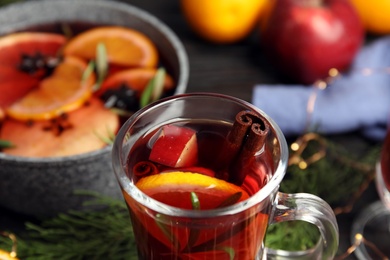 Photo of Tasty mulled wine with spices on table, closeup